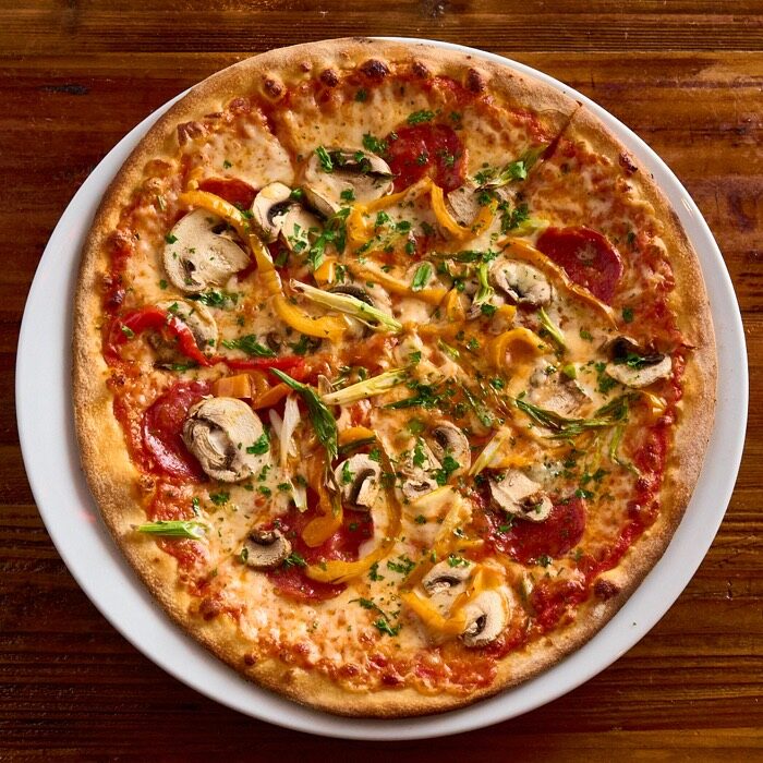 JZ's Signature pizza with roasted peppers, mushrooms, green onion and pepperoni